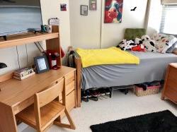One side of a double room in Blanton Hall with a bed and desk decorated by a student.