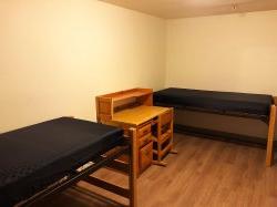霍克十字路口公寓里的双人卧室有两张床和一张桌子.