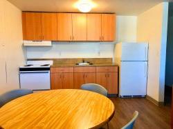 另一张霍克十字区公寓厨房的照片，里面有厨房的桌子和椅子，还有冰箱和炉子.